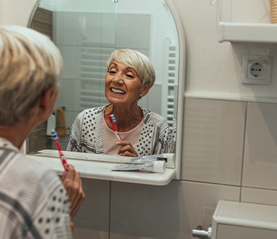 Dentures patient in Dallas looking in the mirror