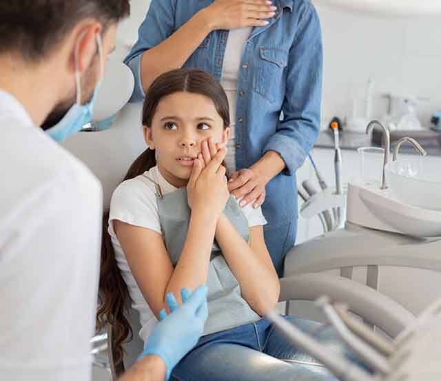 A little girl about to receive emergency dental care