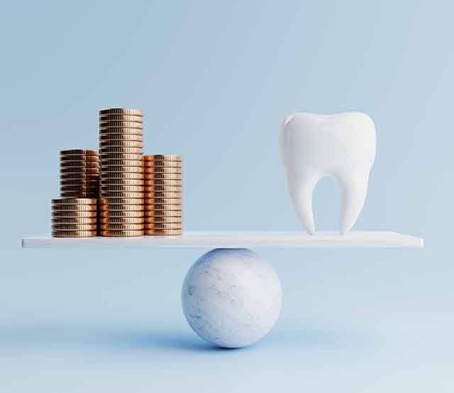 A stack of coins and an enlarged tooth sitting on a balance beam