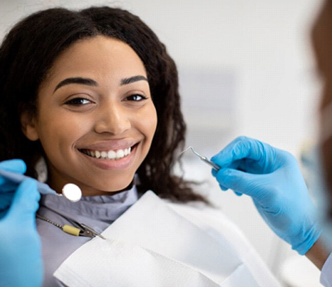 a patient smiling while visiting her united healthcare dentist