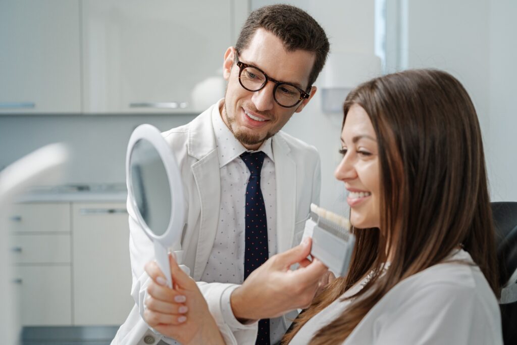 Patient looking at reflection in mirror with shade scale